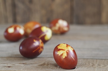 Easter eggs painted onion peel with a pattern of fresh herbs on a wooden ancient background. We color the eggs according to the old eco-friendly method with peeled onions.