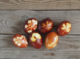 Easter eggs painted onion peel with a pattern of fresh herbs on a wooden ancient background. We color the eggs according to the old eco-friendly method with peeled onions.