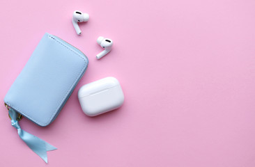 Wireless headphones on a pink background, space for text