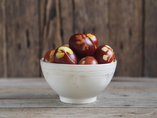 Easter eggs painted onion peel with a pattern of fresh herbs on a wooden ancient background. We color the eggs according to the old eco-friendly method with peeled onions.