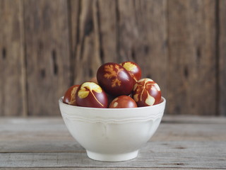 Easter eggs painted onion peel with a pattern of fresh herbs on a wooden ancient background. We color the eggs according to the old eco-friendly method with peeled onions.