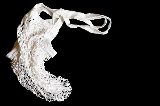 An Empty White String Mesh Bag Is Isolated On A Black Background. Space For Text