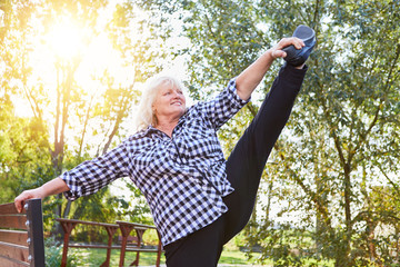 Alte Frau dehnt sich vor Senioren Sport