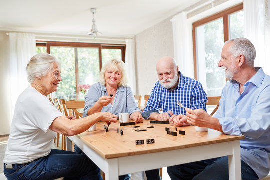 Senioren als Freunde spielen zusammen Domino