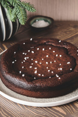 Moist Ginger Chocolate cake sprinkled with sea salt on wooden table. Selective focus. Haze effect