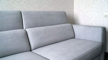Comfortable sofa in the apartment. Part of the sofa in the frame. Ivory sofa