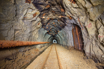 Old gold mine underground tunnel with rails