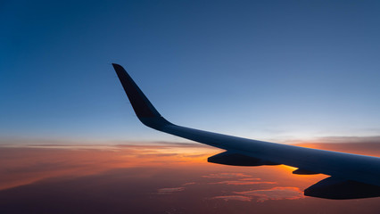 airplane wing on sunset background