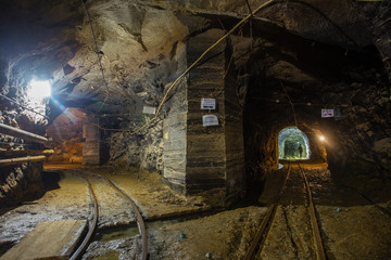 Fototapeta na wymiar Gold mine underground tunnel with rails two ways
