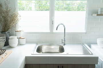 Close up of modern kitchen island with built in sink and white countertops