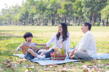 Happy Asian family has leisure in the park on the weekend or holiday. Mother and healthy...