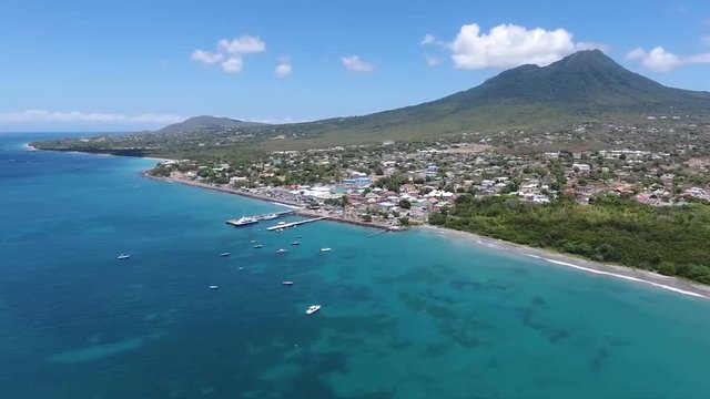 Saint Kitts and Nevis, Caribbean - The Stunning Scenery Of Bright Blue Ocean and Coral Reef Underwater With Beautiful Mountain - Aerial Shot 