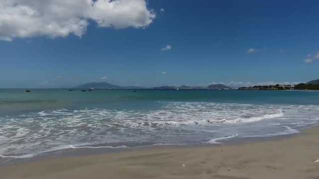 Saint Kitts and Nevis, Caribbean - Waves Crashing On The Shore During Sunny Day - Wide Shot