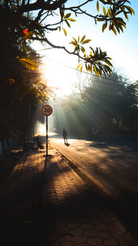 Alone person standing under the sunlight on a road