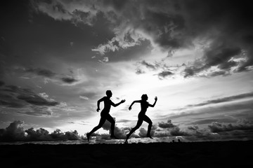 silhouettes of athletes running along the beach / sports summer in the warm sea, healthy rest, sports activity, summer vacation