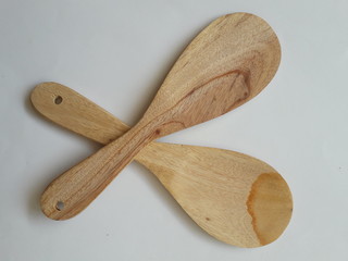 Two rice spoons made of wood with a white background.