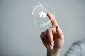 Cropped view of woman pointing with finger on house isolated on grey