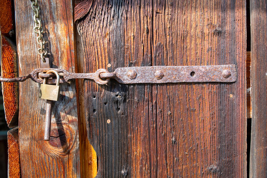 antique gate of a wooden slider with bolt and padlock