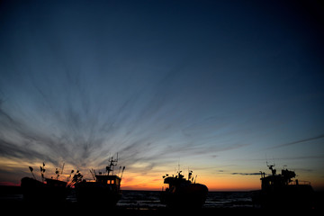 kutry rybackie na plaży i zachód słońca