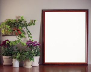 Blank frame  with flower pot decoration on wooden table with white wall background.