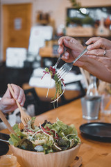 woman eating salad in restaurant