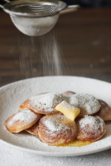 Dutch Mini Pancakes (Poffertjes). Fluffy mini pancakes that are served with a mess of powdered sugar and butter.