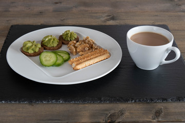 breakfast on a white plate with a cup of coffee.
