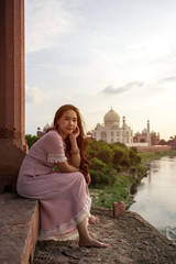 Asian woman posing over Taj Mahal, Agra, India