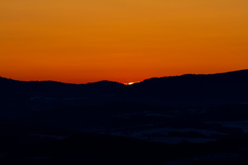 sun hidden behind a hill