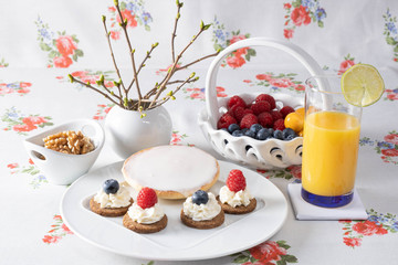 Obraz premium Orange juice with different berries and cakes.