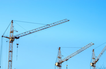 construction cranes against the blue sky. Place under the text, copy space. Concept construction, construction