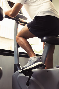 Fit Man Working Out On Exercise Bike At The Gym. Healthy And Funny Lifestyle Concept.