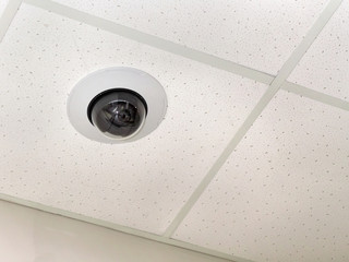 close-up circular surveillance camera on the ceiling of the room
