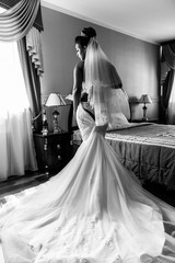 African American bride in lingerie and bathrobe in the morning preparing for the wedding in a hotel...