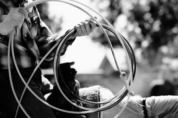 Rope in hand close up of cowboy for western roping lifestyle in black and white.