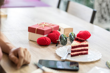 Heart shaped yarn, gift box and sun glasses on the table.