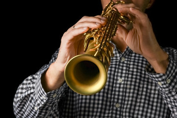Obraz premium soprano saxophone in hands on a black background