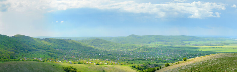 Naklejka premium Mountain landscape and small village in distance