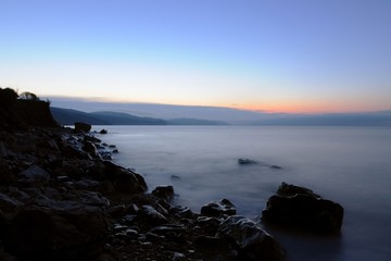 Fototapeta na wymiar Sunset by the sea, beach strewn with stones