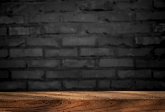 Images of an old wooden table, selected focus, empty brick wall, for editing photos or displaying your product.