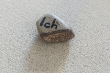 Stein mit Aufschrift Ich auf Sand liegend mit Handabdruck