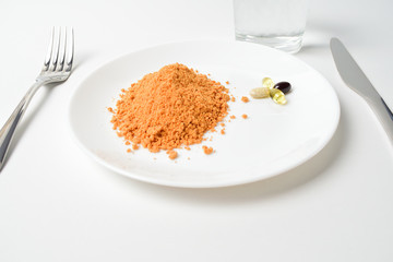 Tomato protein soup powder and multivitamins on a plate. Meal replacement. Dry soup. Multivitamins, astaxanthin, fish oil, omega pills.