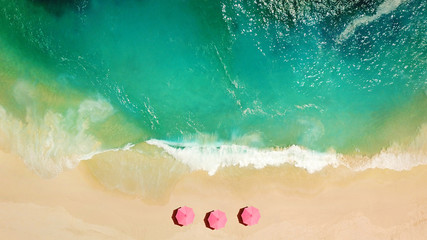 Aerial top view on the beach. Umbrellas, sand and sea waves - obrazy, fototapety, plakaty
