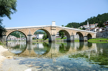 Old bridge above the river with crystal clear water at summer. Ottoman bridge architecture. Stone...