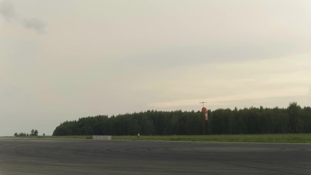 Wide shot of Windsock at airport. Forest in the background