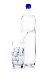 Blue plastic bottle of mineral water and glass with ice cubes and straw on white background