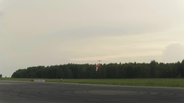 Wide shot of Windsock at airport. Forest in the background