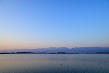 Scenic views of the lak with a mountainous backdrop against blue sky