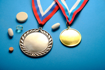 Medals on a blue background, pills, doping symbol