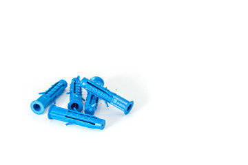 Several construction dowels for the screws lie erratically close-up on a white background.